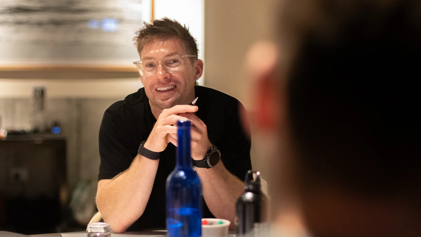 A trade business owner laughing across a table at an Academy event