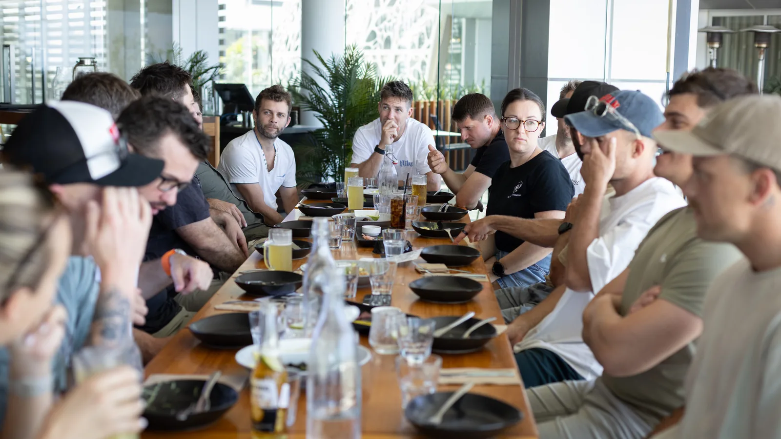 Sixteen trade business owners down both sides of a long table at an Academy event, mid conversation over dinner