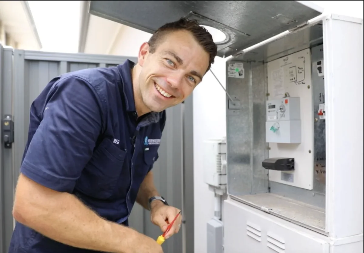 Greg Allan on the tools early in his trade, working on a job in high-visibility workwear