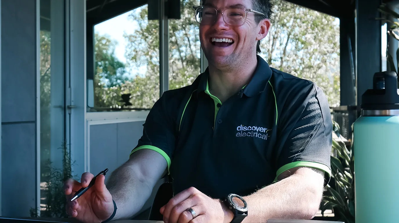 A trade business owner laughing in the middle of a session, pen still in his hand and his notebook open in front of him